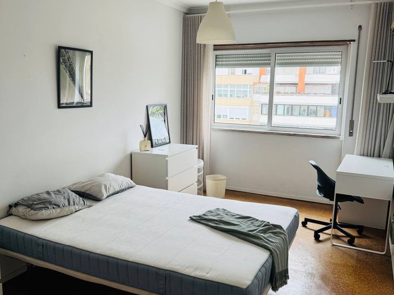 Double bed, chest of drawers and a desk by the window, which looks onto Avenida do Brasil.